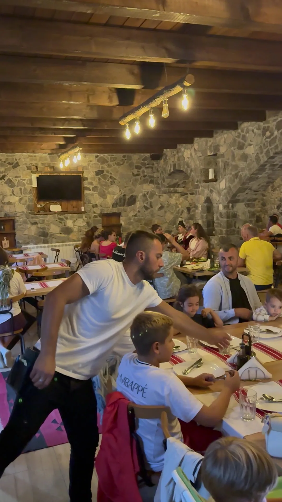 Mysafirë që hanë në tryezën e gjatë të sallonit